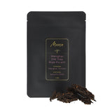 Menghai Old Tree Ripe Pu-erh front packaging photo. A black pouch with a label with a piece of broken tea cake