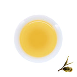 A cup of brewed White Peony, next to brewed tea leaves