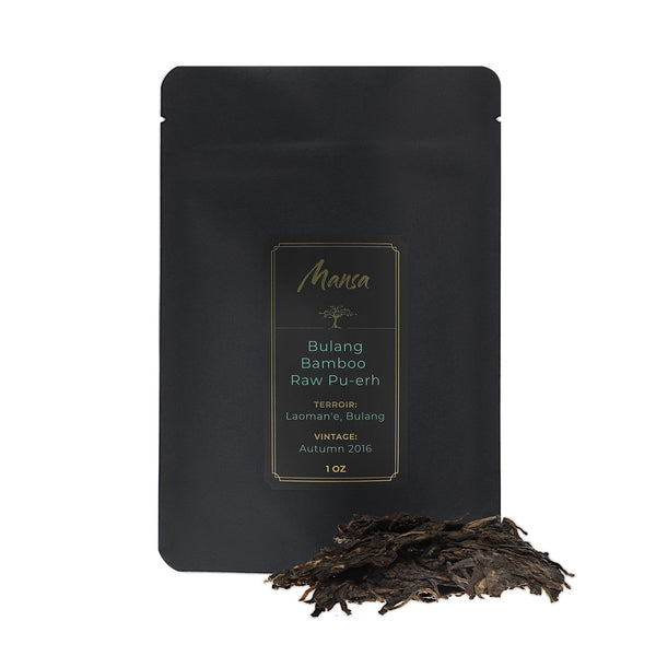Bulang Bamboo Raw Pu-erh front packaging photo. A black pouch with a label with a piece of broken tea cake