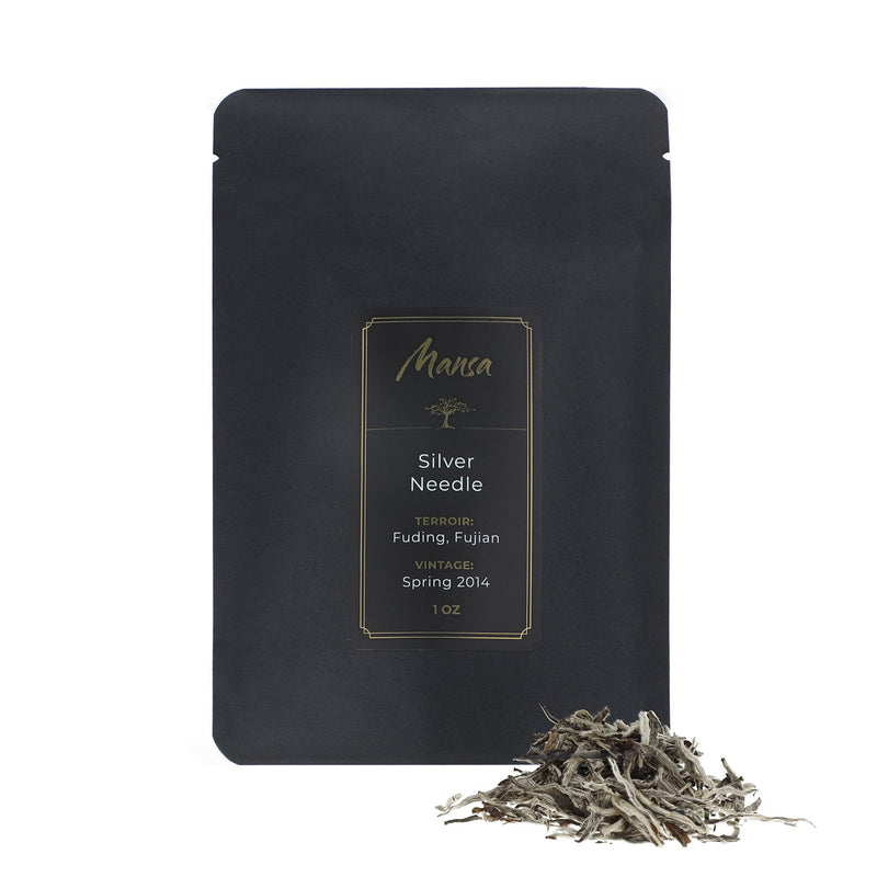 Fuding Silver Needle front packaging photo. A black pouch with a label with a piece of broken tea cake