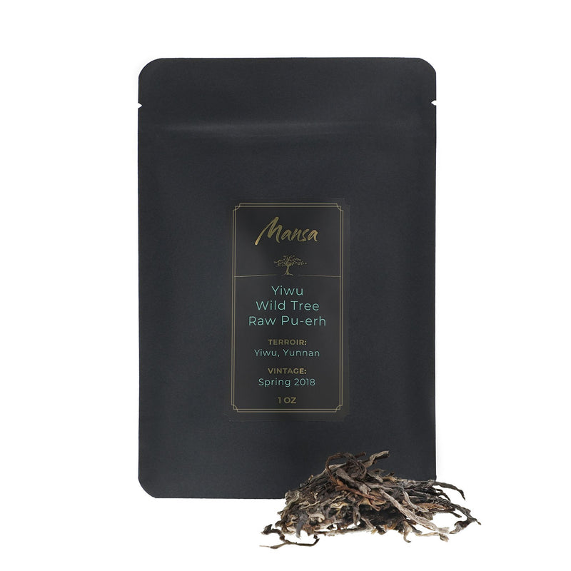 Yiwu Wild Tree Raw Pu-erh front packaging photo. A black pouch with a label with a piece of broken tea cakae
